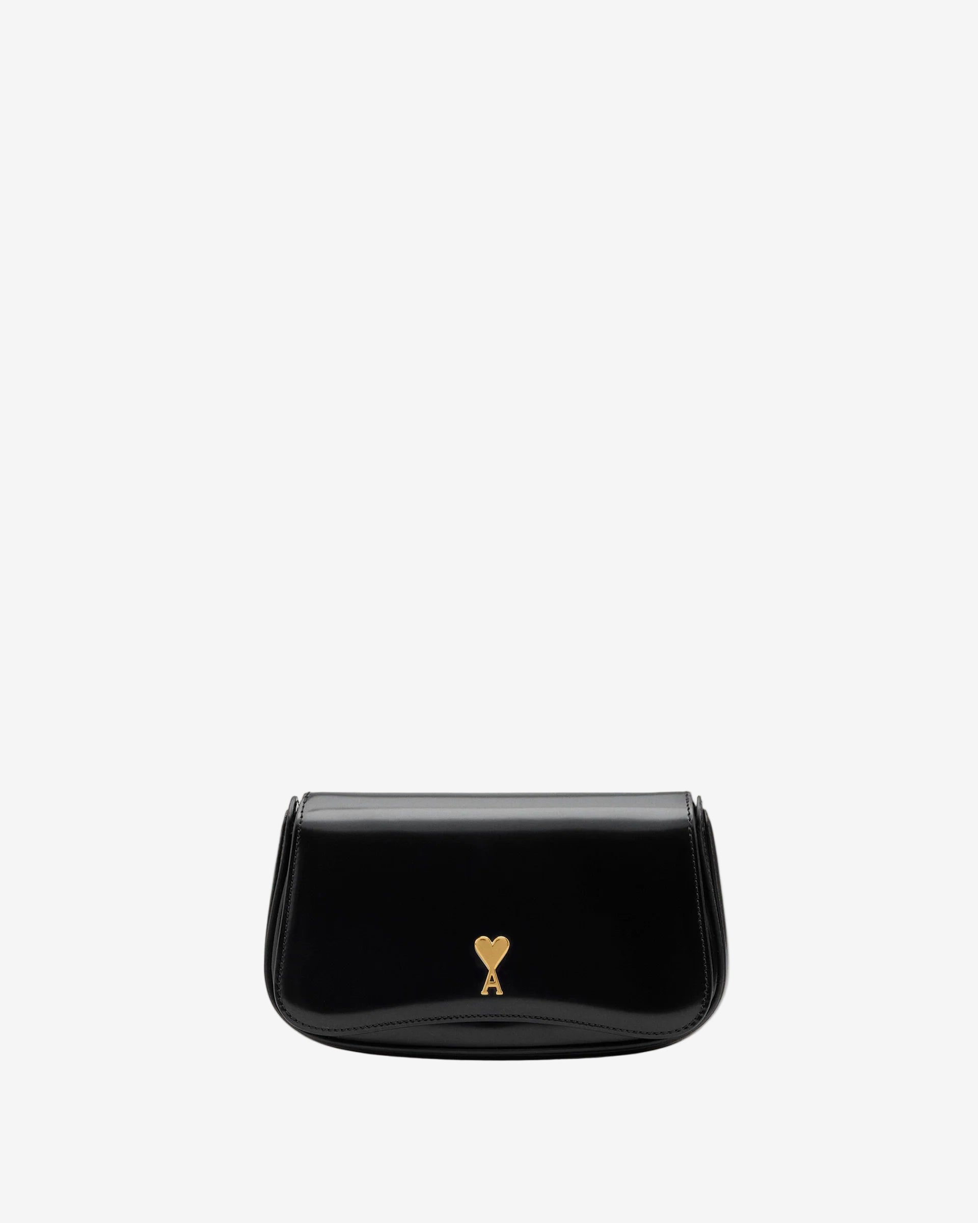 Person holding a black handbag with a gold emblem against a neutral background ami paris
