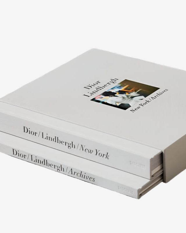Stack of books titled 'Dior/Lindbergh/New York' on a textured surface