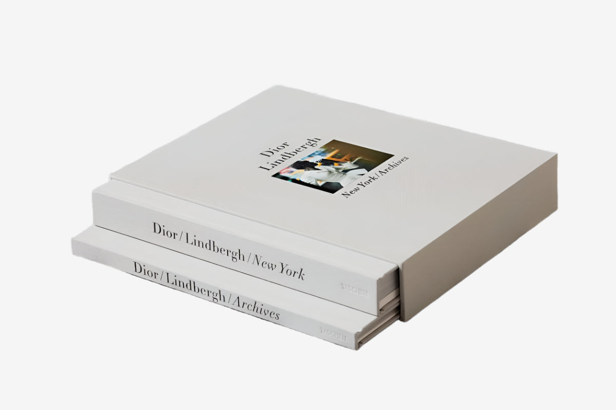 Stack of books titled 'Dior/Lindbergh/New York' on a textured surface
