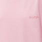 A light pink short-sleeve t-shirt with a small tonal pink ATTICO' logo on the left chest, displayed on a neutral light gray background.