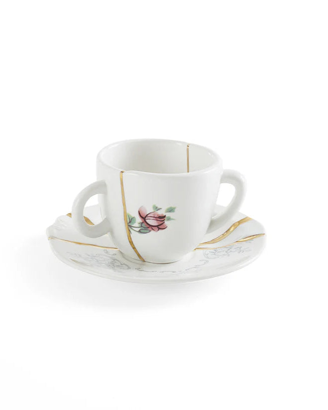 White ceramic cup and saucer with floral design on a white background