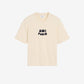 Beige t-shirt with 'AM! PARIS' text on a light gray background