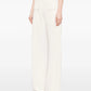 Person wearing white wide-leg pants on a plain background