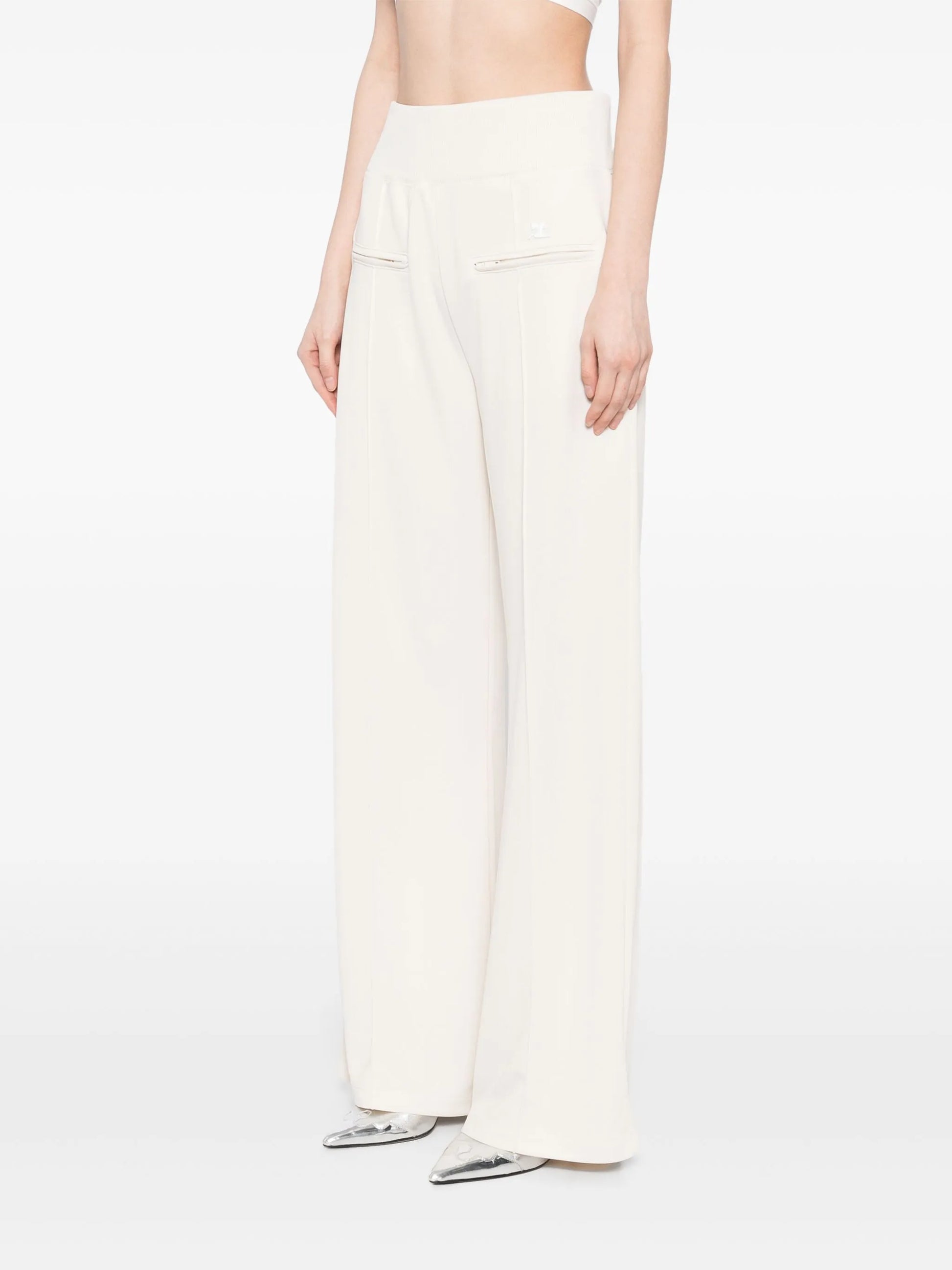 Person wearing white wide-leg pants on a plain background