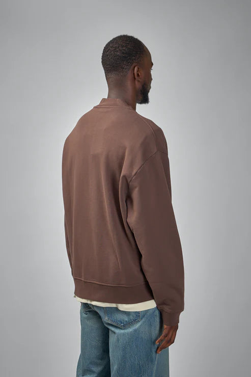 Brown jacket with a visible brand label on a white background