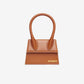 Brown handbag with 'Jacquemus' branding on a light gray background