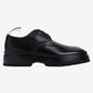 Black leather shoe on a light gray background