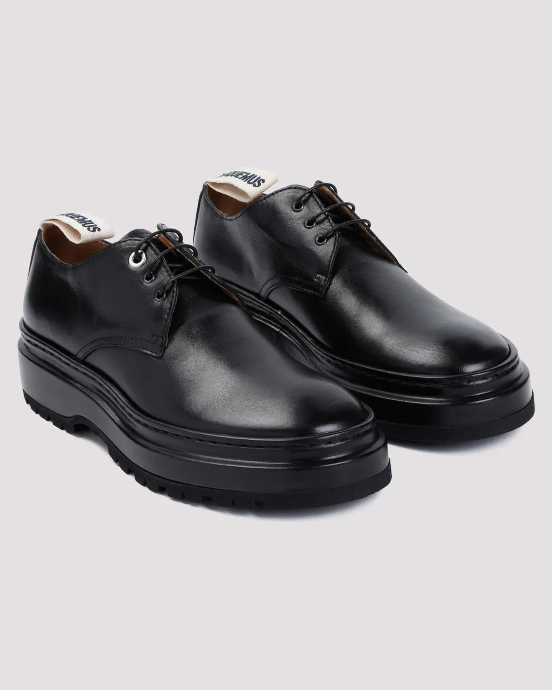 Pair of black leather shoes on a light gray background