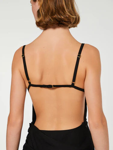 Black dress with thin straps and a draped design on a white background
