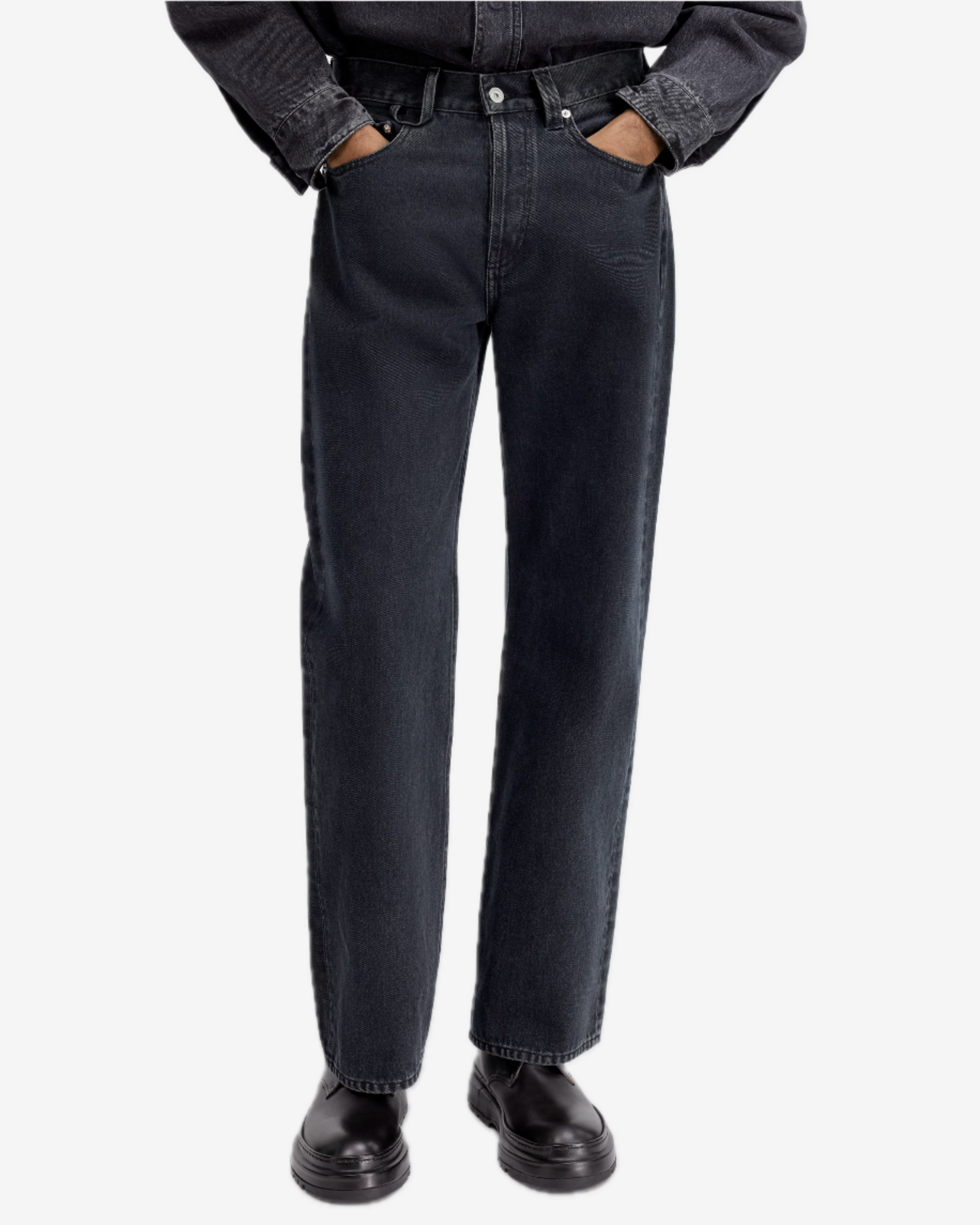 Person wearing black jeans and black shoes on a white background