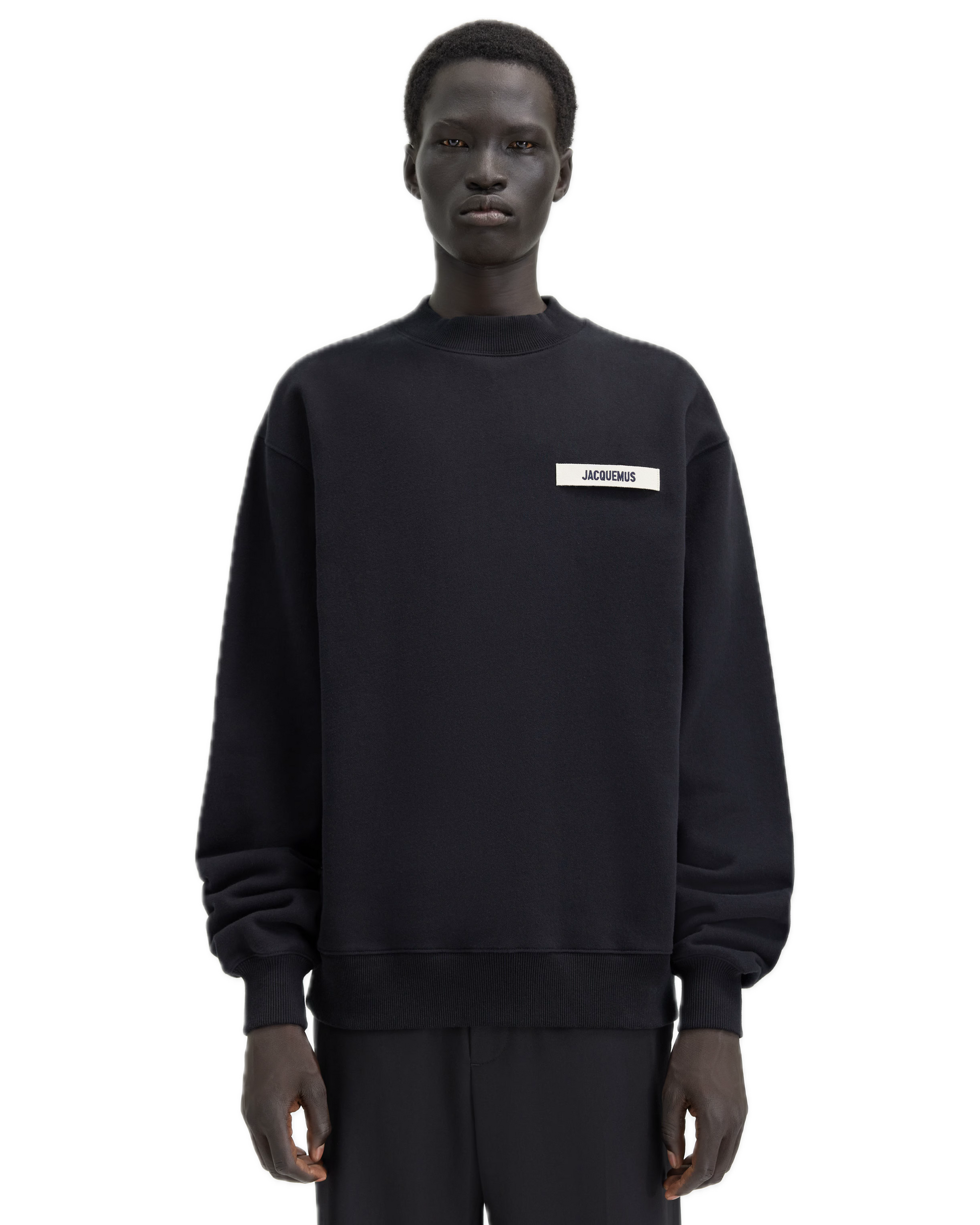 Person wearing a black sweatshirt with a logo on a white background
