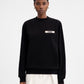 Person wearing a black sweatshirt with a logo on a white background