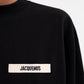 Person wearing a black sweatshirt with a logo on a white background