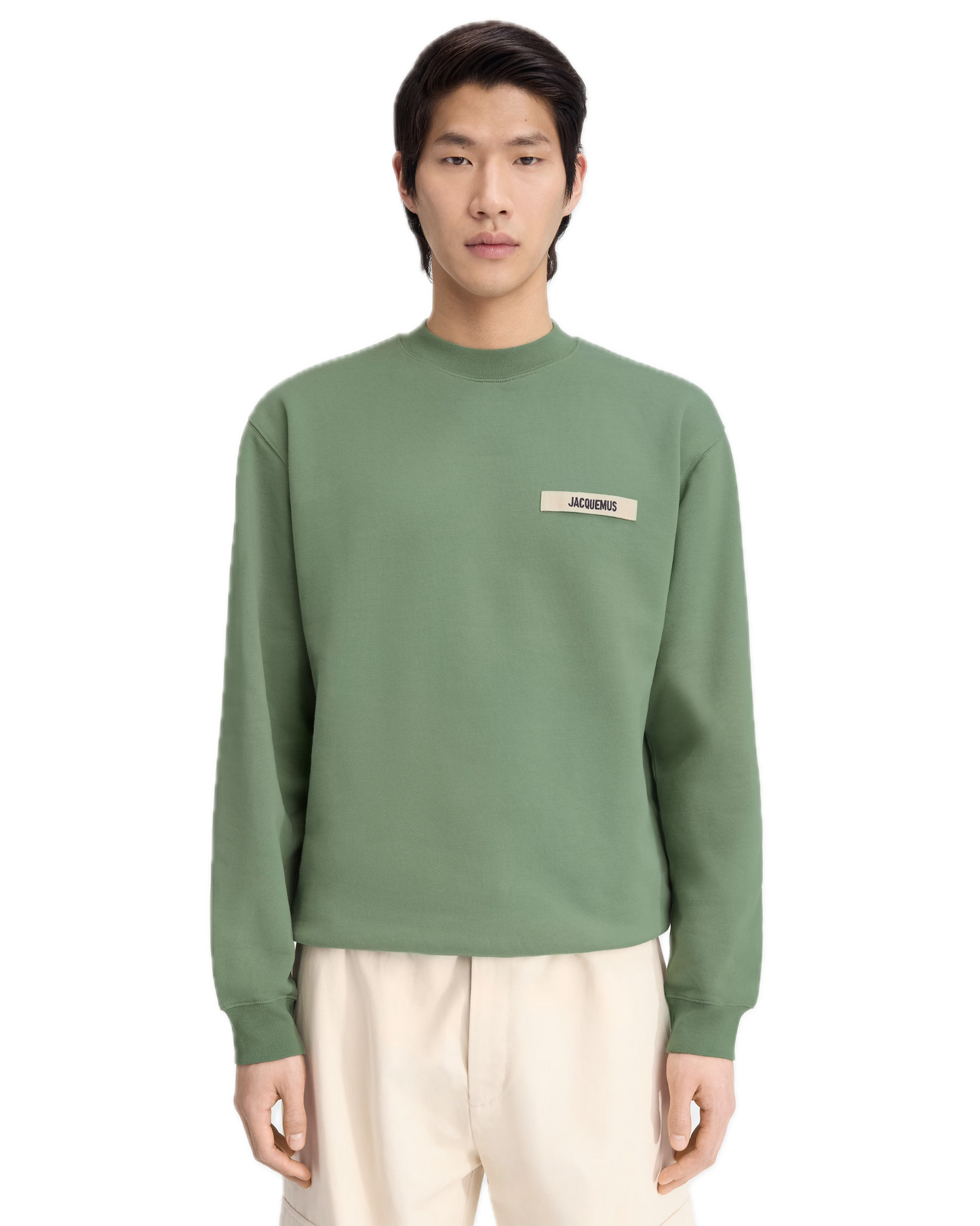 Person wearing a green sweatshirt with a logo on a white background