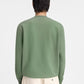 Person wearing a green sweatshirt with a logo on a white background