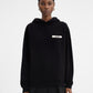 Person wearing a black hoodie with a brand logo on a white background