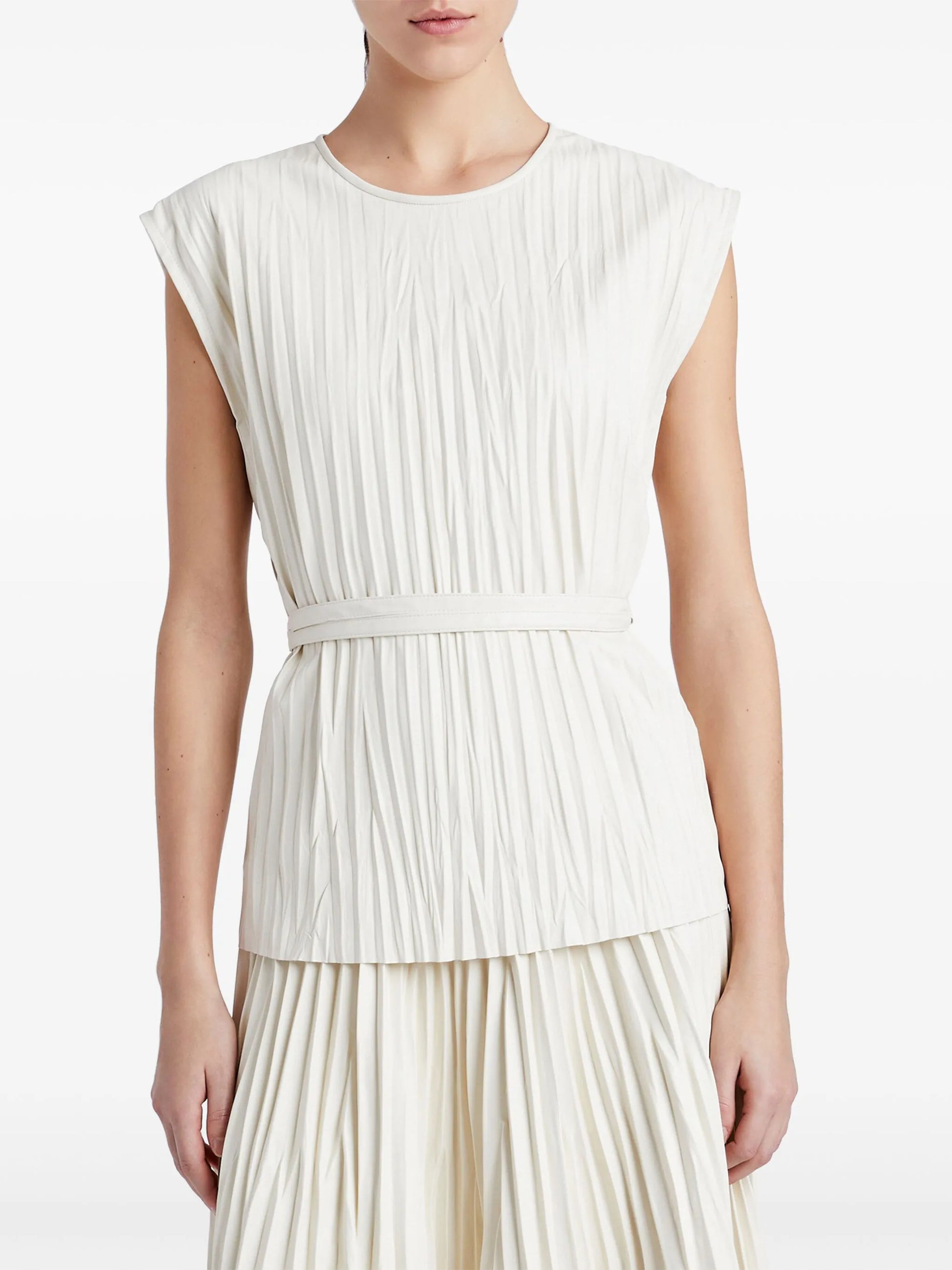 Woman wearing a white pleated dress on a white background
