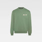 Person wearing a green sweatshirt with a logo on a white background