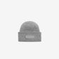 Gray knit beanie with a patch on a white background