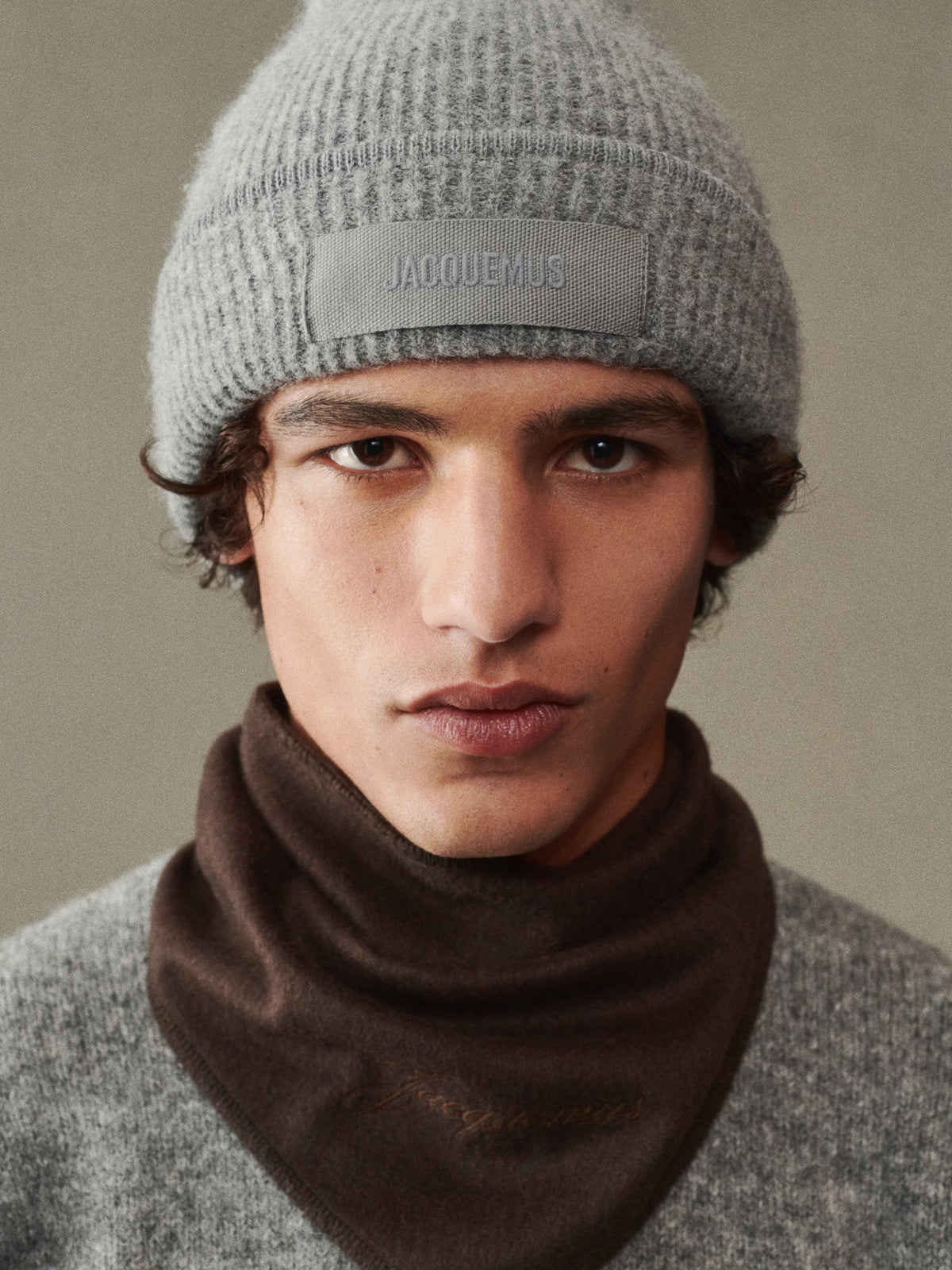 Gray knit beanie with a patch on a white background