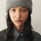 Gray knit beanie with a patch on a white background