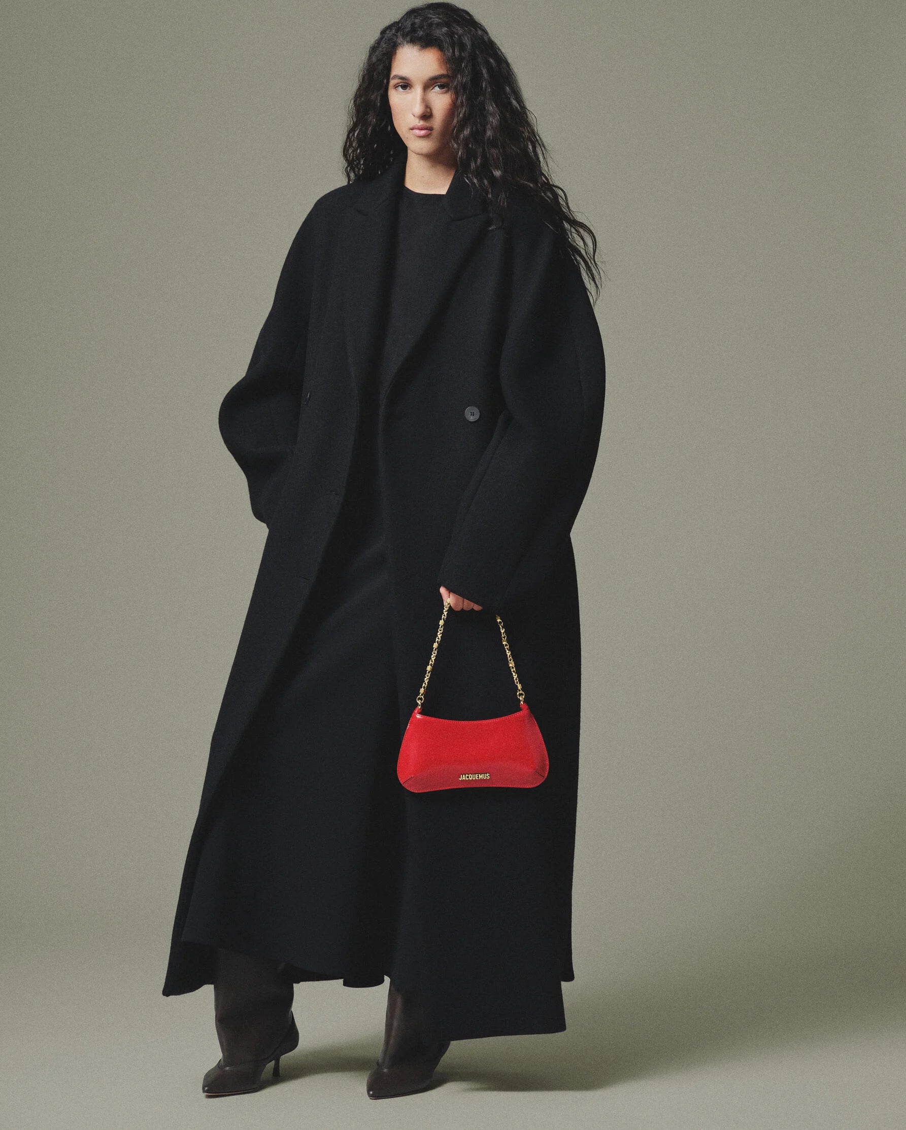 Red handbag with gold chain strap on a white background