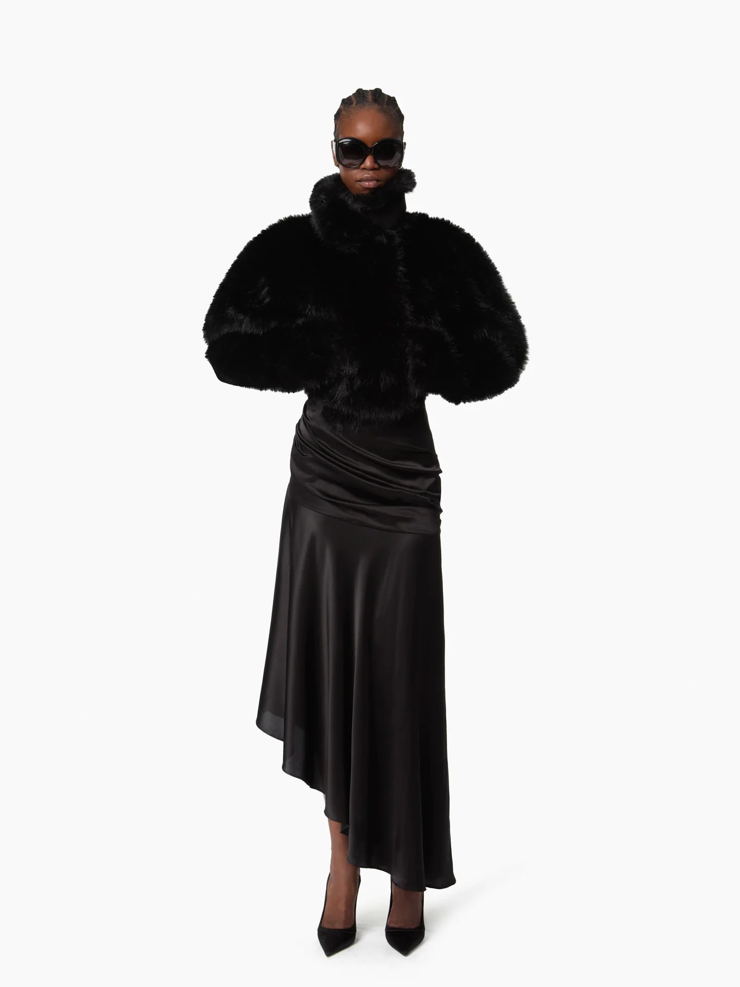 Person wearing a black fur coat and skirt on a white background