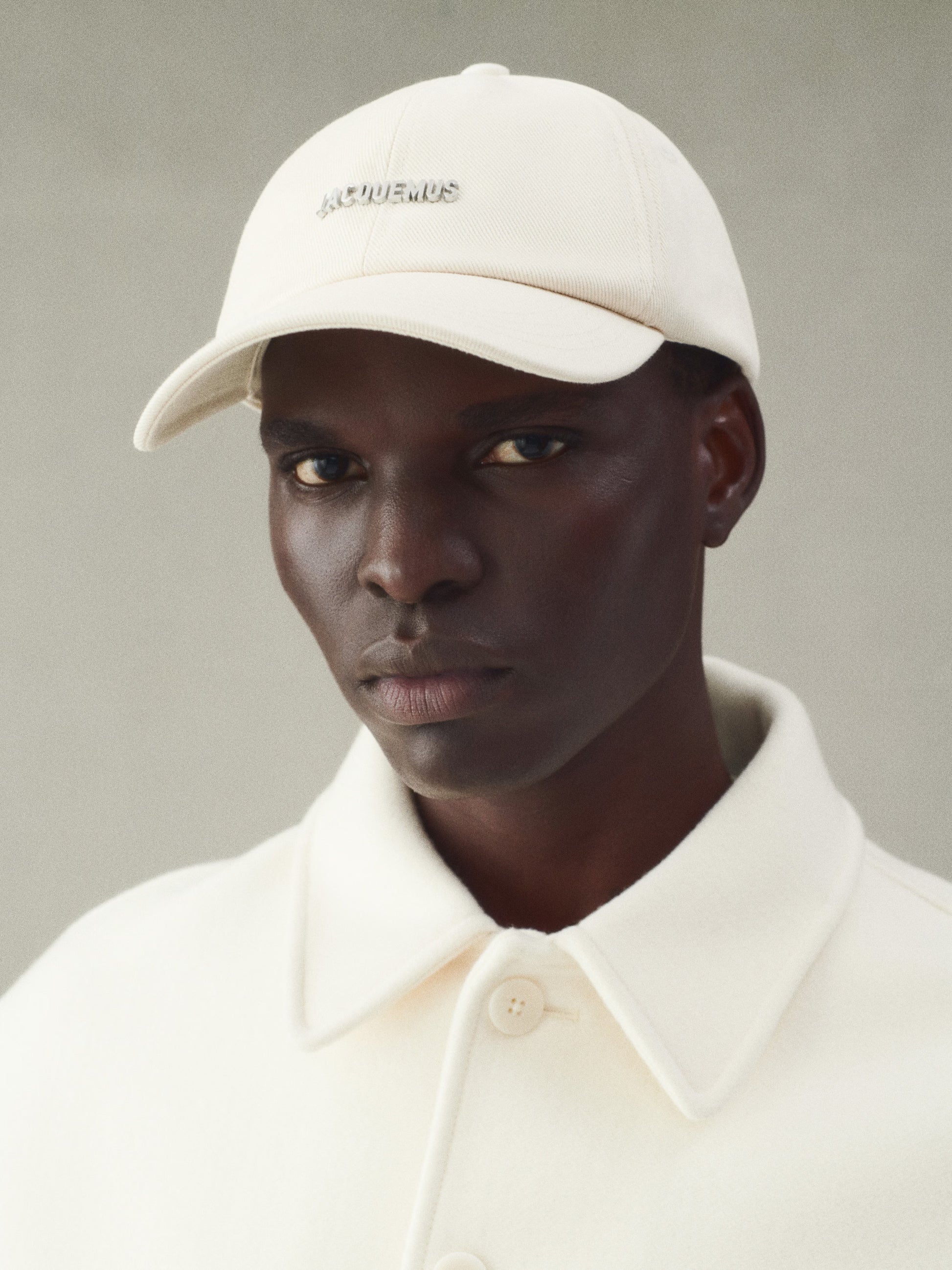 Beige cap with 'JACQUEMUS' branding on a white background