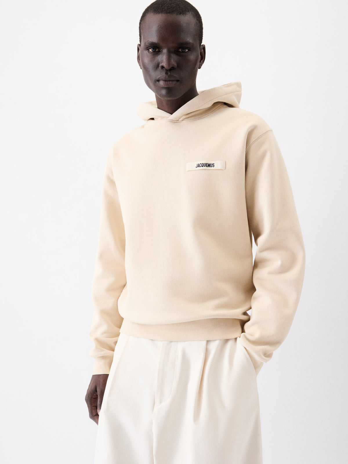 Beige hoodie with a brand logo on a white background