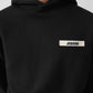 Black hoodie with a small logo on the chest against a white background