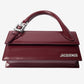 Red handbag with a visible brand logo on a light gray background