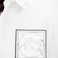 White shirt with a small black logo on the chest against a white background