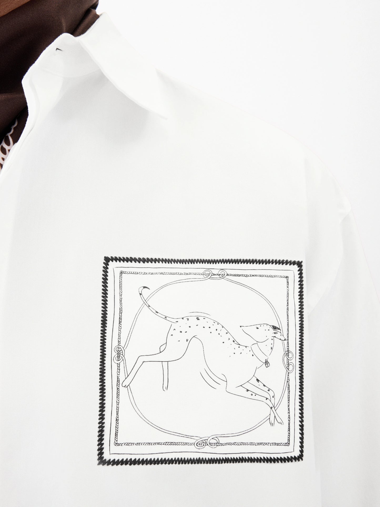 White shirt with a small black logo on the chest against a white background