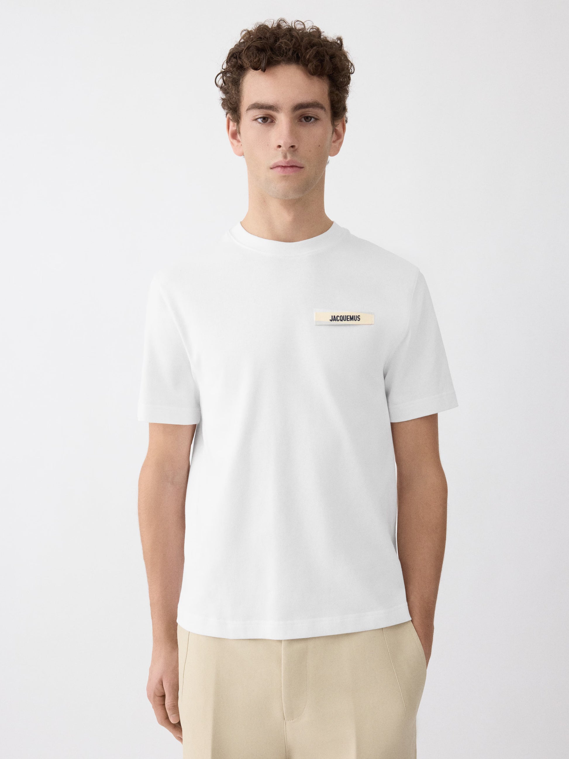 White t-shirt with a small logo on a white background