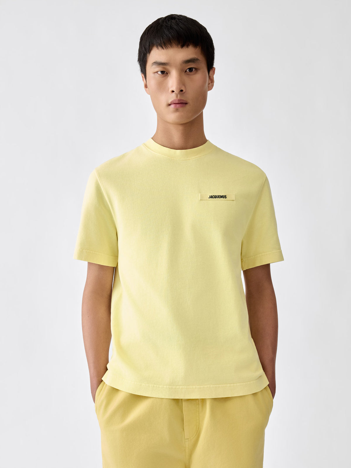 yellow t-shirt with a small logo on a white background