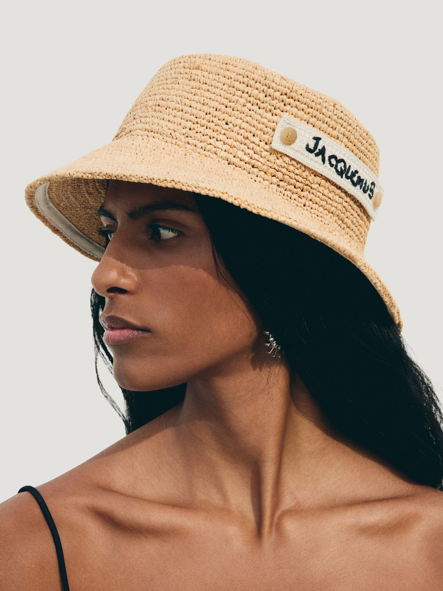 Beige bucket hat with 'Jacquemus' label on a white background