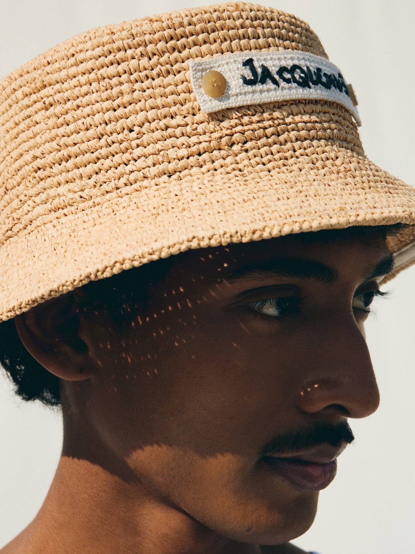Beige bucket hat with 'Jacquemus' label on a white background
