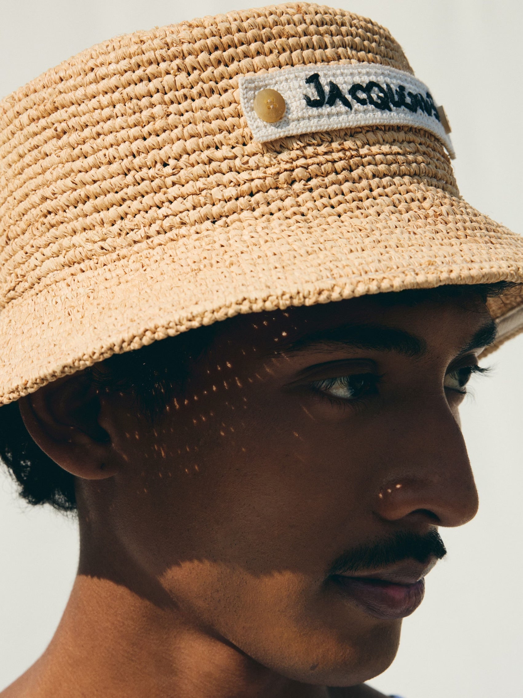 Beige bucket hat with 'Jacquemus' label on a white background