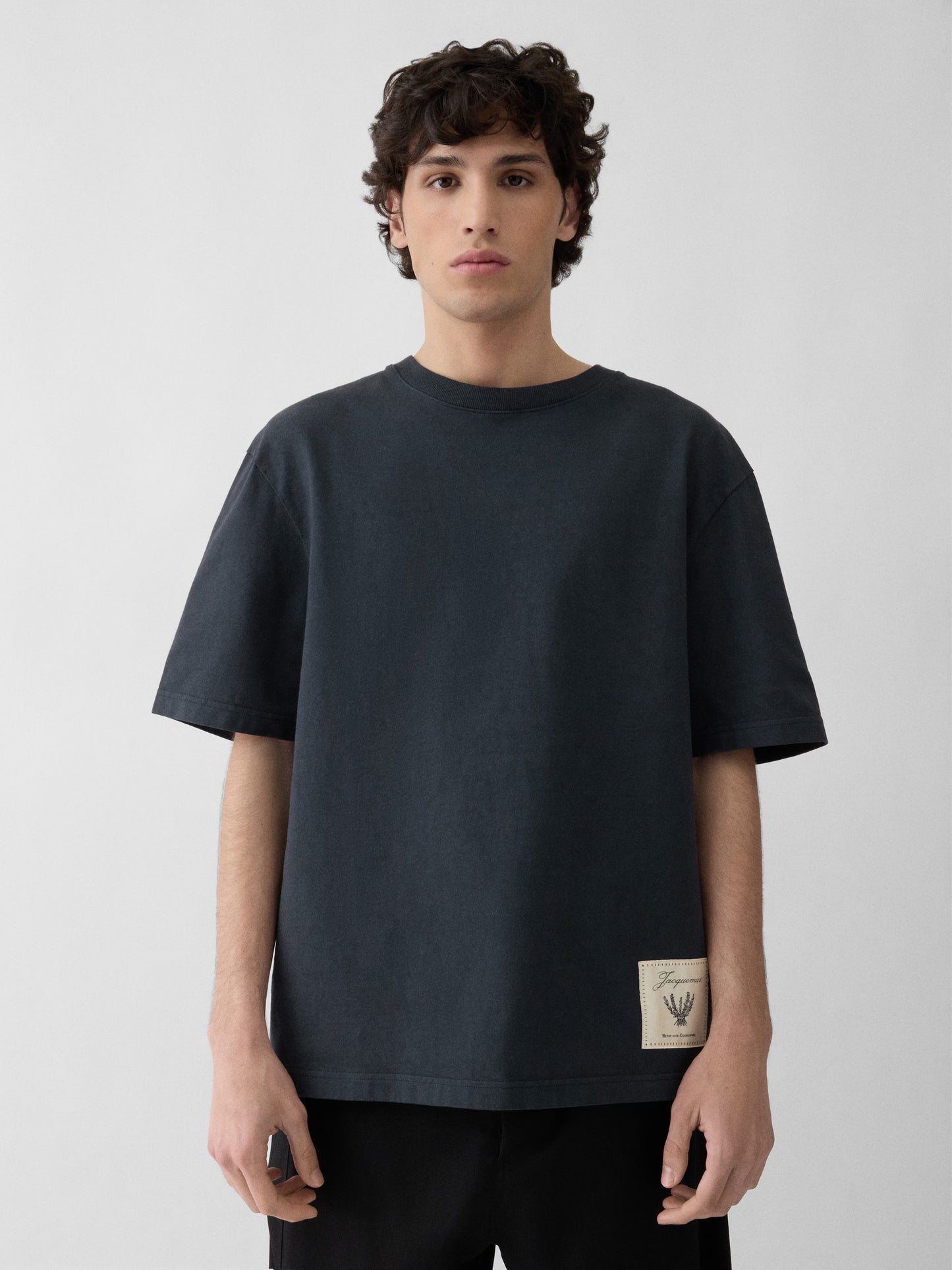 Navy t-shirt with a beige label on a light gray background JACQUEMUS