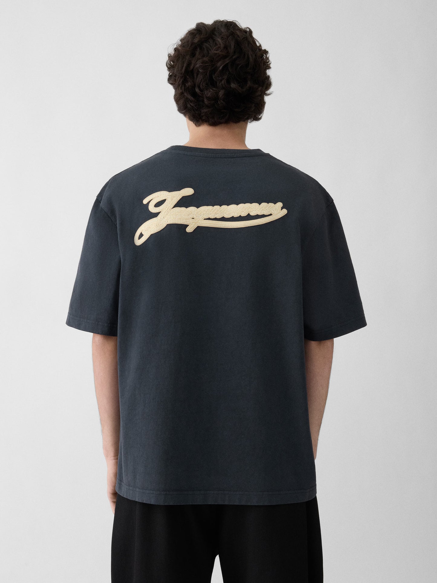 Navy t-shirt with a beige label on a light gray background JACQUEMUS
