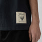 Navy t-shirt with a beige label on a light gray background JACQUEMUS