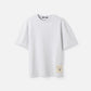 Grey t-shirt with a beige label on a light gray background JACQUEMUS