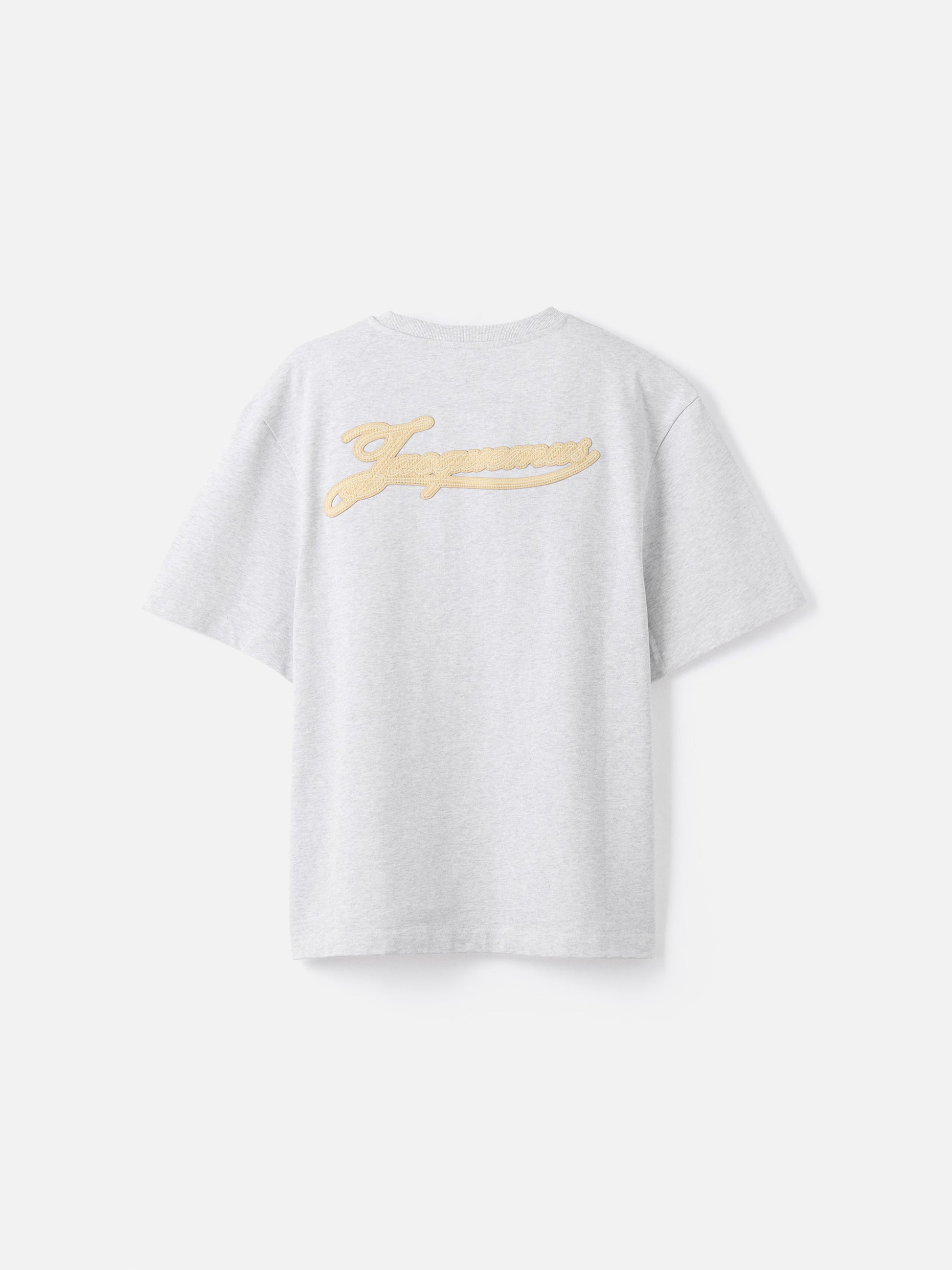 Grey t-shirt with a beige label on a light gray background JACQUEMUS