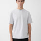 Grey t-shirt with a beige label on a light gray background JACQUEMUS