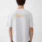 Grey t-shirt with a beige label on a light gray background JACQUEMUS