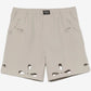Beige shorts with cut-out designs on a white background