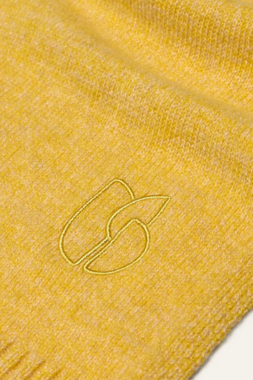 Close-up of a yellow textured fabric with a logo on a white background