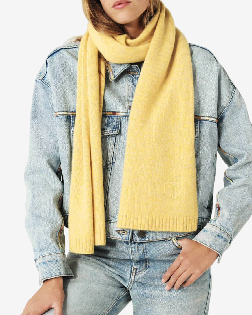 Person wearing a yellow scarf, denim jacket, and jeans on a white background