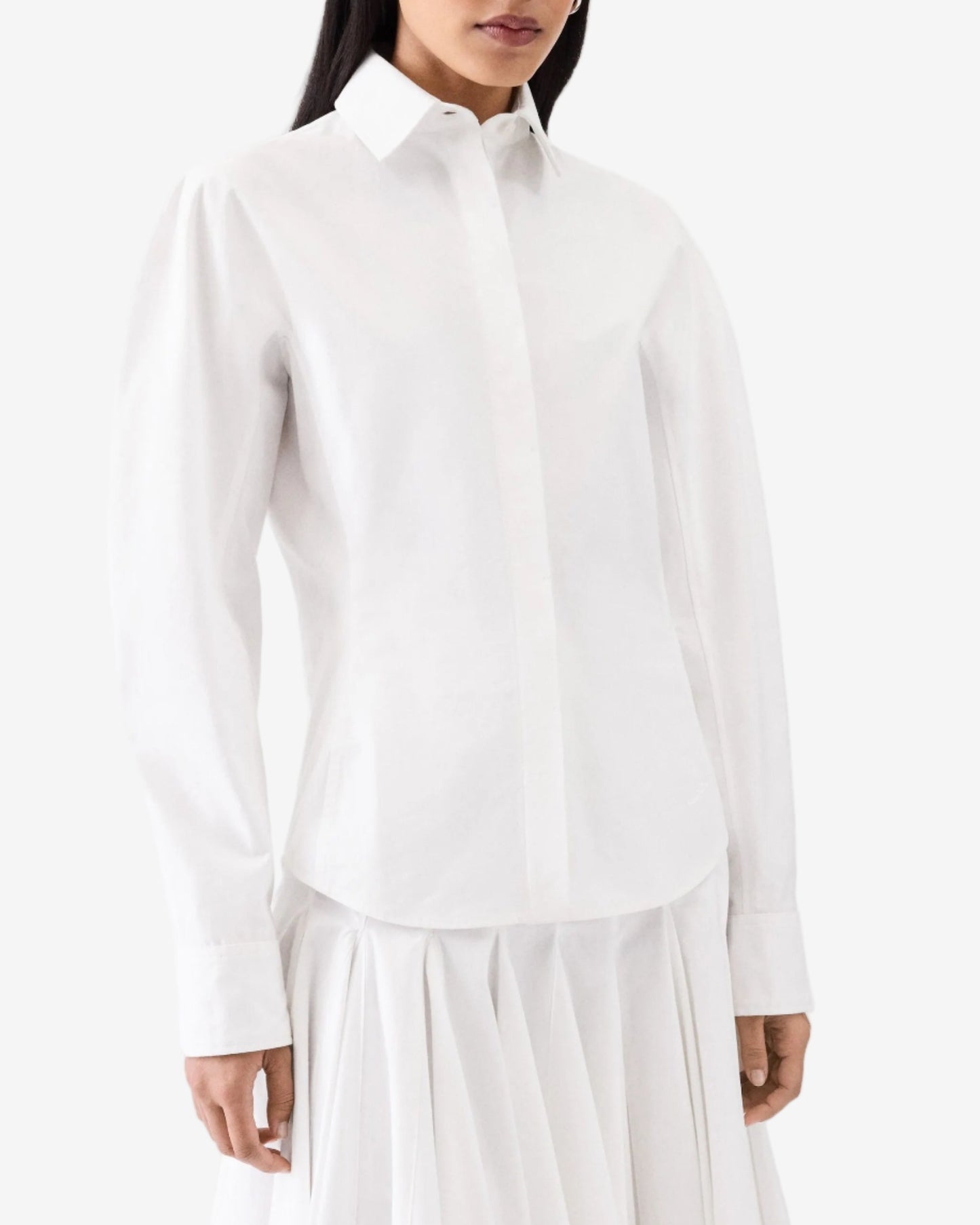Person wearing a white shirt and white pants on a white background