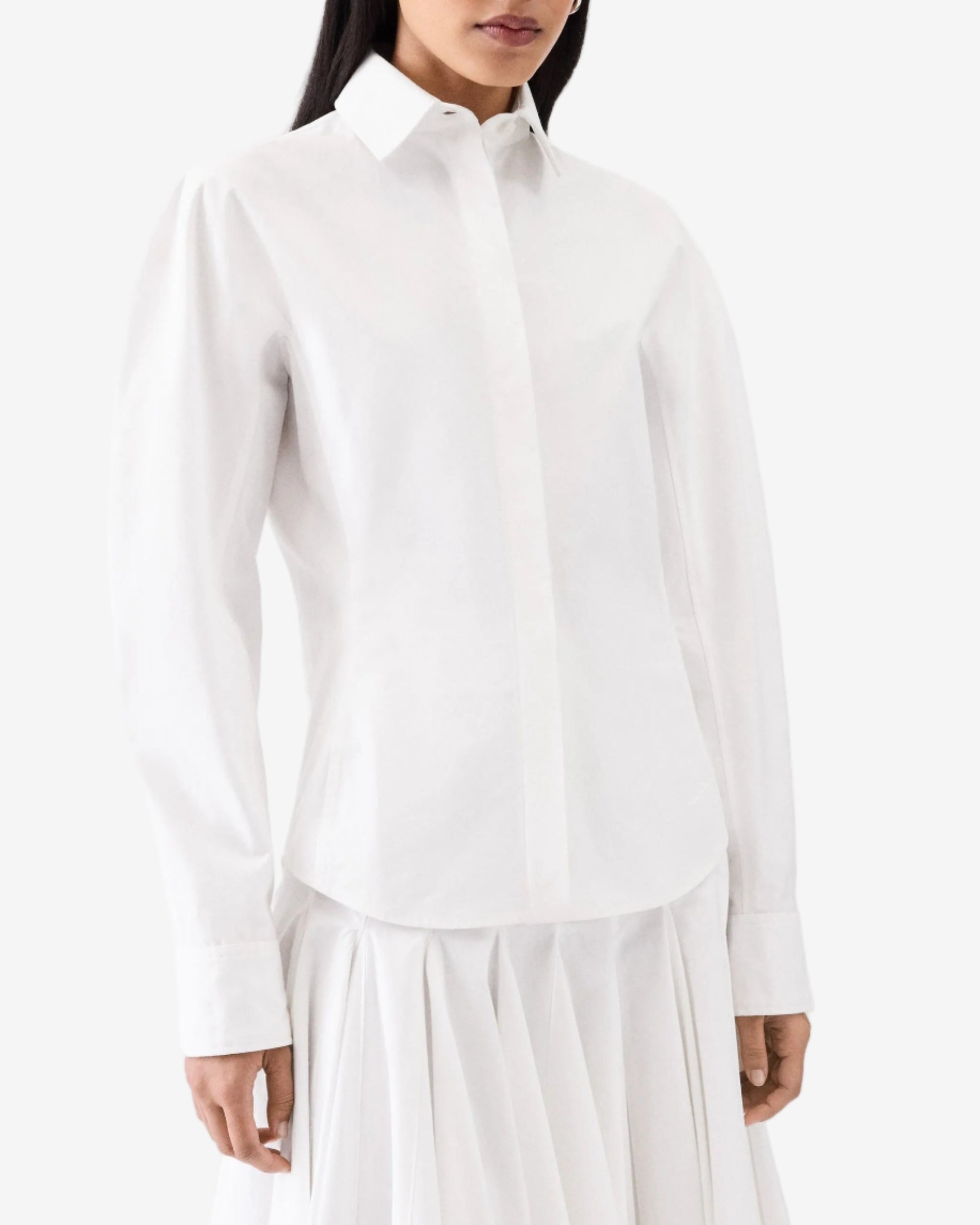 Person wearing a white shirt and white pants on a white background